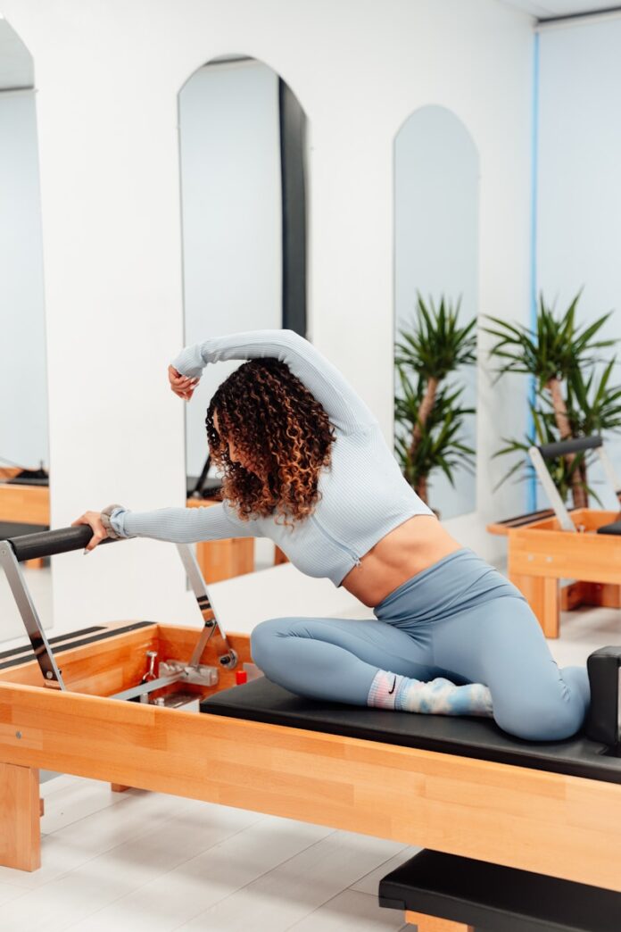 Photo by Ahmet Kurt a woman is doing exercises on a rowing machine