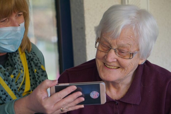 Photo by Georg Arthur Pflueger woman in brown button up shirt holding white smartphone