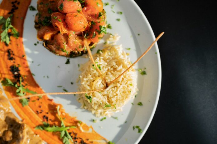 Photo by HamZa NOUASRIA a white plate topped with meat and rice