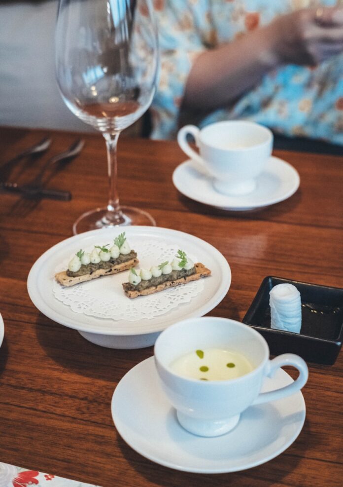 Gourmet appetizers and soup served on a wooden table.